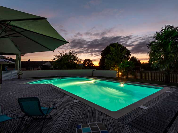 Vue de la piscine chauffée du Clos des Séguineries le soir